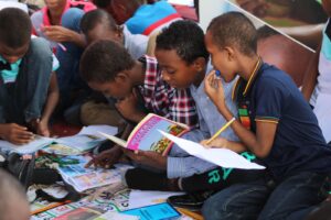 Photo by Ismail Salad Osman Hajji dirir boy in blue and white plaid shirt reading book